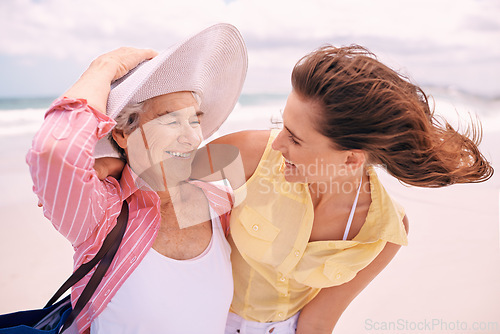 Image of Senior, mother and woman with beach wind or vacation bonding on tropical island or holiday, happiness or retirement. Old person, daughter and hat at Florida seaside or travel tourism, relax or trip