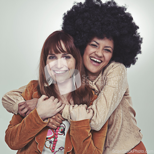 Image of Vintage, portrait and friends with retro style, smile and laugh with hug in studio with grey background. Girls, happiness and unique with fashion in outfits, clothes and women with confidence