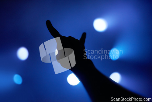 Image of Horns, silhouette and music with hand at concert for performance, nightclub and musician. Celebration, party and audience with closeup of person and rock gesture for support, crowd and festival