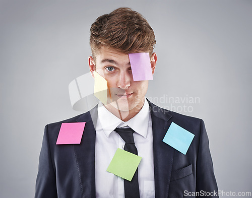 Image of Business man, overwhelmed and sticky note on face, suit or clothes in studio portrait by background. Person, employee or corporate staff with paper, reminder or ideas for schedule, meeting or report