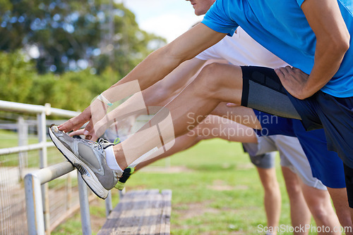 Image of Group, people and outdoor for stretching legs on bench for warm up, workout and training together on grass. Sports, team and exercise on field for health, wellness and fitness in nature with friends