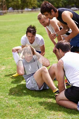 Image of Man, sit ups for exercise and cheers from team with support and coaching, fitness and training on sports field. Challenge, action and core workout outdoor with athlete friends, motivation and help