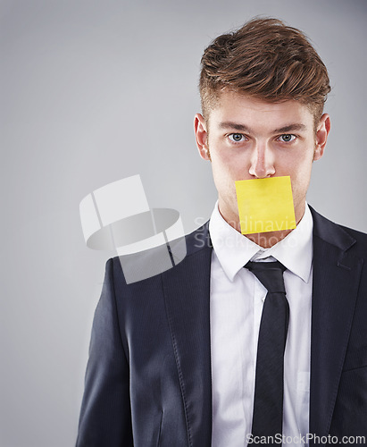 Image of Business man, sticky note and mouth in portrait for silence, reminder and studio by white background. Person, employee and corporate workout with paper on lips for compliance, censorship and quiet