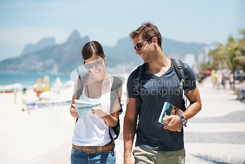 Image of Couple, tourist and beach with map for guide on holiday, tour and travel for summer in Rio de Janeiro. Relationship, vacation and happy in seaside for trip in adventure, together and smile for break