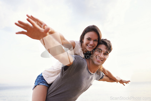 Image of Couple, beach and piggyback with freedom, smile and nature with travel and date for relationship. Man, woman and indonesia sea for adventure, vacation and tropical holiday with sunshine and portrait