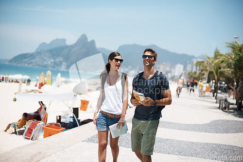 Image of Couple, tourist and walk in beach with map on holiday in summer, trip and happy in Brazil. Relationship, vacation and bonding in seaside for summer with adventure, travel and smile for break.