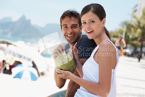 Image of Couple, coconut and drink at beach with smile for vacation with milk, cocktail and juice in portrait. People, man and woman with sunshine, review and fruit for water, happy and detox with nutrition