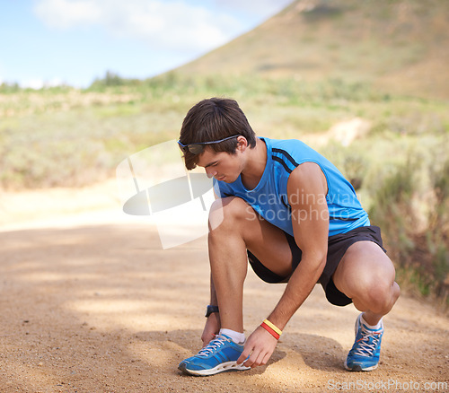 Image of Tie, running or man with shoe lace for fitness training, walking exercise or workout on path or sand. Runner, wellness or male sports athlete with footwear ready to start outdoor cardio in nature