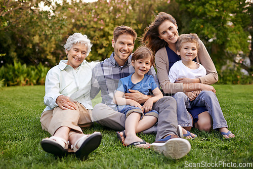 Image of Nature, portrait and children with parents and grandmother relaxing on grass in outdoor park or garden. Smile, family and boy kids on lawn with mom, dad and grandma for bonding in field together.