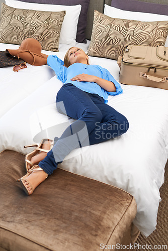 Image of Woman, hotel room and bed relax with suitcase for travel holiday or accommodation, vacation or weekend. Female person, lying and tourist hospitality in Miami for packing luggage, comfortable or rest