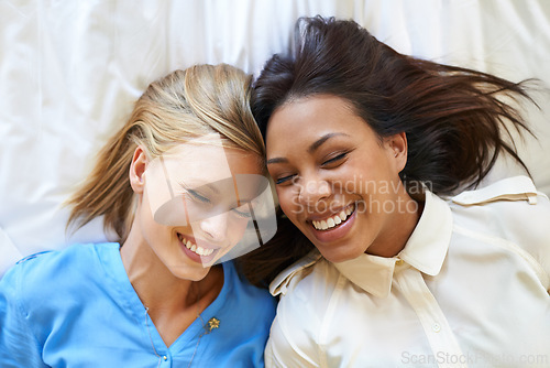 Image of Women, friends and bed relax as top view with holiday accommodation for bonding weekend, connection or vacation. Female people, group and happiness in Miami for hospitality, resting or comfortable