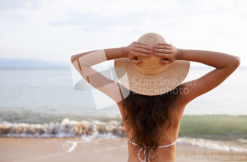 Image of Hat, hands up or woman at sea for travel adventure to relax on holiday vacation in summer or Bali. Back, breathe or female person at beach with open arms in nature for fresh air, freedom or gratitude