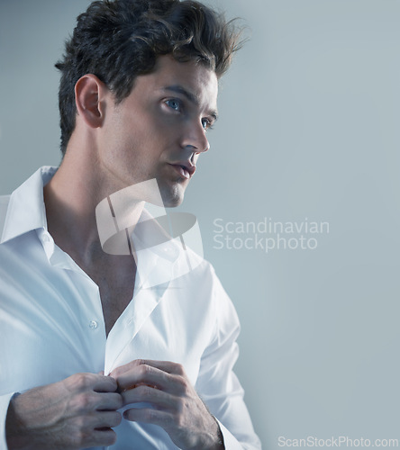 Image of Thinking, shirt and business man getting ready in studio isolated on gray background for start of career. Face, fashion and button with serious young employee dressing in outfit for interview