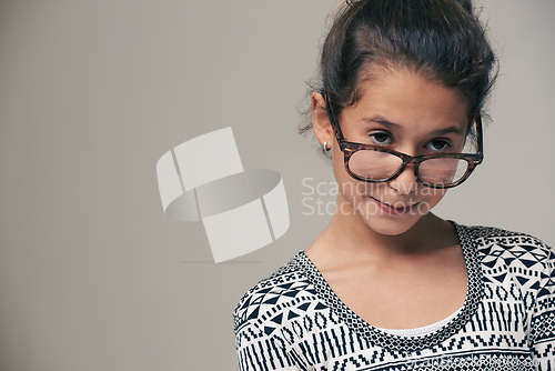 Image of Girl, child and glasses in studio with space, thinking and mock up for style, vision and eye care by background. Kid, model and frame with eyesight, wellness and nerd for optometry in childhood