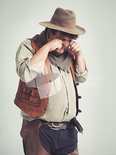 Image of Cowboy person, crying and sad in studio, bandit and plus size man on white background. Dress up, fake and Halloween outfit or character, Texas criminals and vintage for retro theme in costume