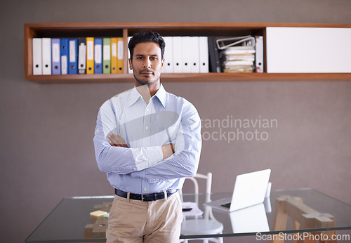 Image of Office, portrait and businessman with arms crossed in confidence and pride in asset management. Corporate, investor and working on portfolio in workplace with laptop for research on stock market