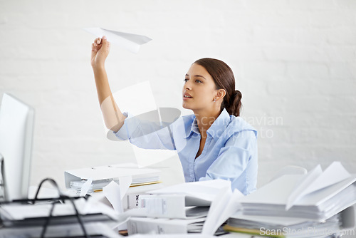Image of Corporate, businesswoman and paper plane at desk, sitting and thinking while working. Employee and paperwork with files in professional workspace, procrastination and avoid with distraction game
