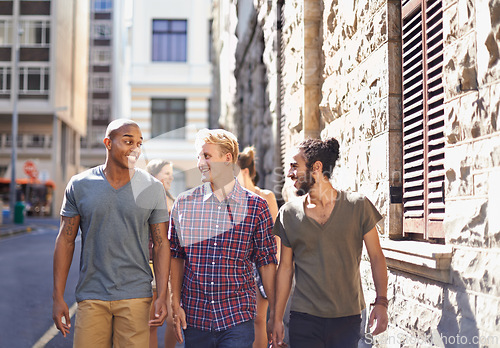 Image of Male friends, walking and talking in city, smile and conversation on travel holiday. Urban, fun and diverse group of happy men, discussing and bonding while out on stroll in New York on vacation