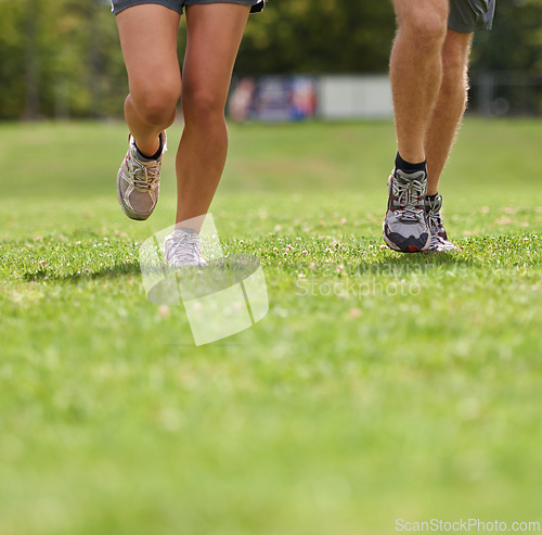 Image of People, running shoes and closeup on grass for workout together in summer for health, wellness or training. Person, runner and partner with feet on field for exercise, fitness and speed with sneakers