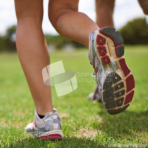 Image of People, running shoes and closeup on grass for exercise together in summer for health, wellness or training. Person, runner and partner with feet on field for workout, fitness and speed with sneakers