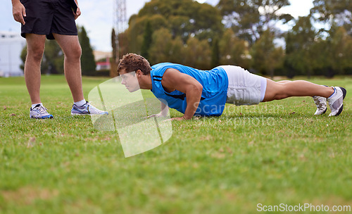 Image of Men, push up and personal trainer on field for exercise with counting for stats, progress or development. Person, coach or mentor with inspection for balance, training or workout for health on grass