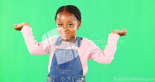 Image of Little girl, face and clueless with smile on green screen for question against a studio background. Portrait of African American child or kid smiling with arms in air, unsure or doubt on mockup