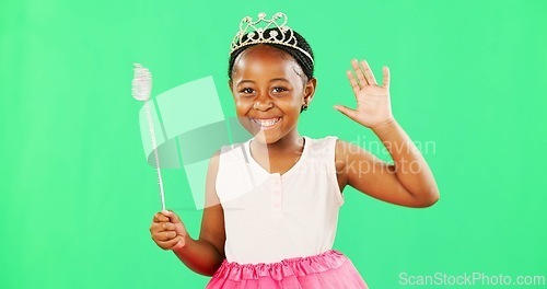 Image of Children, wave and wand with a girl on a green screen background in studio playing fantasy or dress up. Portrait, kids and magic with an adorable little female child waving on chromakey background