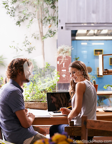 Image of Students, talking and smiling in coffee shop with laptop and notes for studying and break. Young people, friends and cheerful together with tech, internet and email for research or tutor at cafe