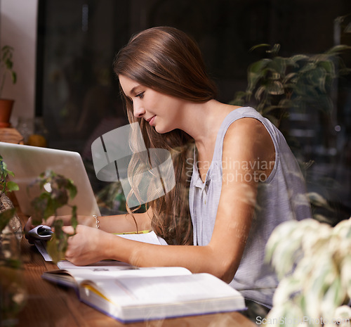 Image of Student, woman and reading in cafe for study, knowledge and education with notebook, laptop and smile. Young person, learning and research in books for assignment, assessment or exam in coffee shop