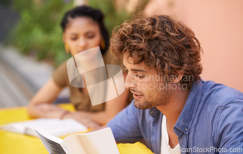 Image of Face, education and student man reading on college or university campus for learning and study. Book, scholarship and pupil with young person outdoor for research on break or recess at school