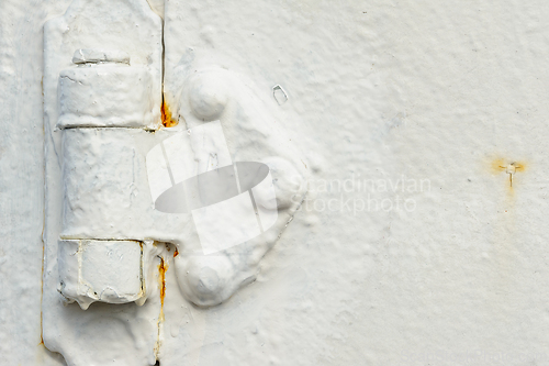 Image of Close-up of peeling white paint on an aged metal surface showing