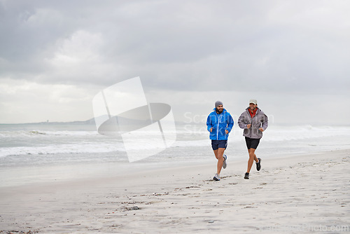 Image of Men, ocean and running on beach, sand and fitness for wellness and gym wear on coast together. Male athletes, jog and training for seaside, health and outdoor for sport and exercise for body workout