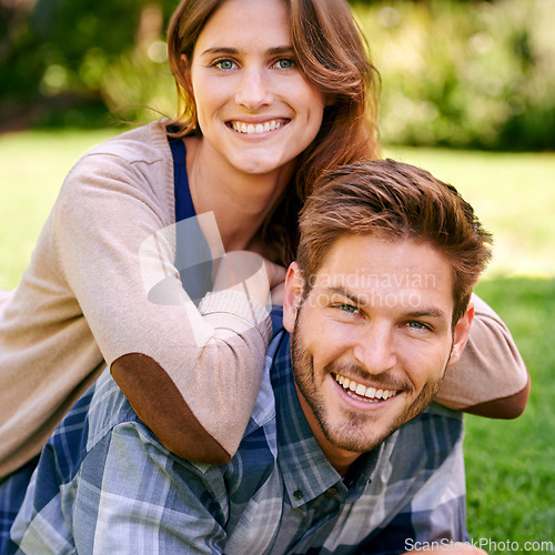 Image of Happy, couple and smile on lawn together, laying and summer portrait to relax in natural environment. Love, family time for caring on holiday and relationship growth, attractive and garden date