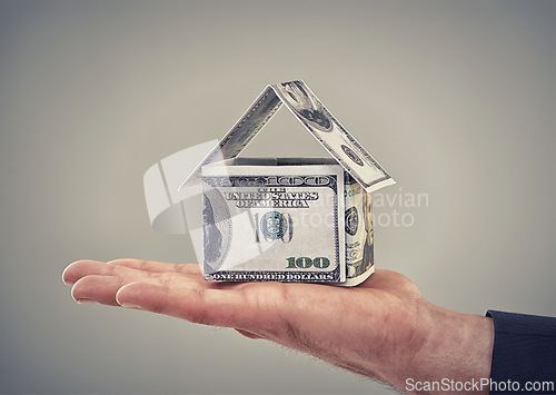 Image of Hand, cash and finance for house in studio with shape for security, real estate or investment by background. Home, insurance with money, dollars and symbol for property, mortgage or rent of building