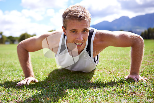 Image of Man, push up and bicep in portrait on grass, strong core and muscle development in training. Male person, fitness and endurance on field, exercise and athlete for workout or bodybuilder challenge