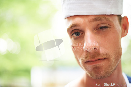 Image of Portrait, hat and man wink outdoor in sailor outfit at music festival, event or summer carnival. Face, blink and serious person at party for celebration concert, bokeh and facial paint in France