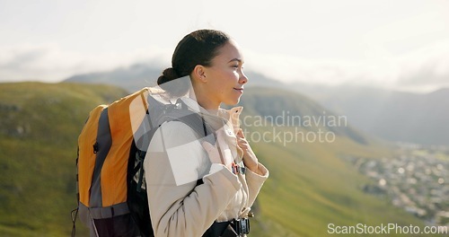 Image of Young woman, trekking on mountains and breathing fresh air for outdoor wellness, fitness and health. Happy person in wind with backpack and hiking in nature on a hill for adventure, travel or journey