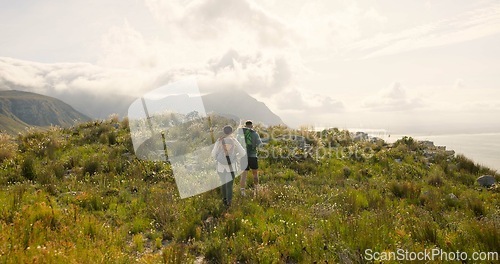 Image of Back of couple trekking, walking on mountains and travel for adventure, wellness and health in nature together. Sports people with backpack for hiking on rocks, green hill and eco friendly journey