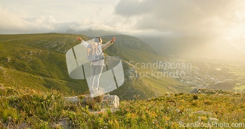 Image of Woman, mountain top and freedom, hiking goals, celebration or travel achievement in nature adventure. Person or winner in backpack with arms up for trekking success, energy and yes on a cliff or rock