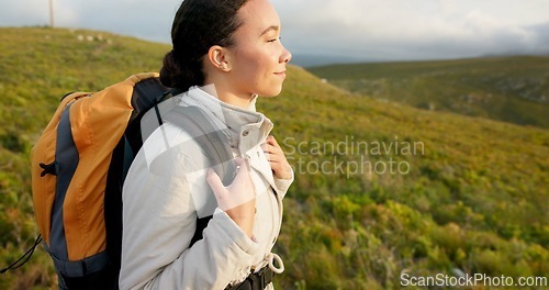 Image of Young woman, hiking on mountain and breathing fresh air for outdoor wellness, fitness and health. Happy person in wind with backpack and trekking in nature on a hill for adventure, travel or journey