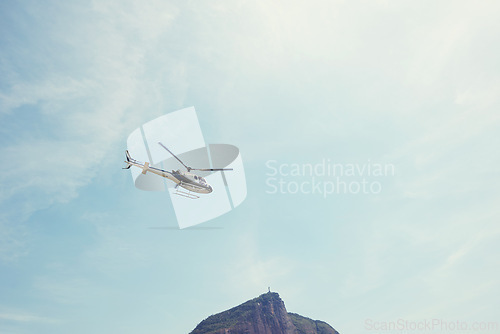 Image of Drone, view and helicopter in a blue sky for travel, adventure or low angle transportation. Flying, freedom or aircraft in nature for search and rescue, cargo or emergency, service and assistance