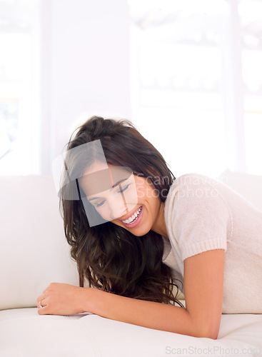 Image of Portrait, laughing or happy woman on couch to relax in living room on holiday in a house or apartment. Lying down, sofa or funny person with smile or wellness on vacation break to rest in alone time