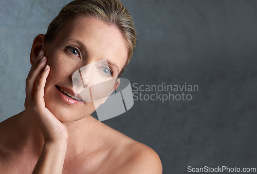 Image of Face, skincare and space with mature woman in studio on gray background for aesthetic wellness. Beauty, relax and mock up with natural skin person at spa for antiaging cosmetics or treatment