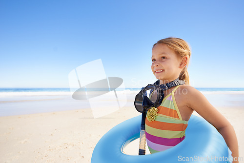 Image of Girl, inflatable and goggles or tube at beach, ocean and equipment for swimming on holiday. Female person, happy child and water on tropical vacation in outdoors, sand and blue sky for mockup space