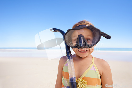 Image of Girl, portrait and goggles for snorkeling at beach, smile and equipment for swimming on holiday. Female person, child and travel on tropical vacation in outdoors, sand and blue sky for mockup space