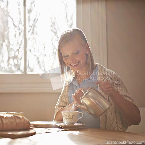 Image of Pouring, tea and happy woman in home for morning, calm routine and drink on table. Girl, relax and coffee break with food, snacks or teapot in hands for breakfast preparation on holiday or vacation