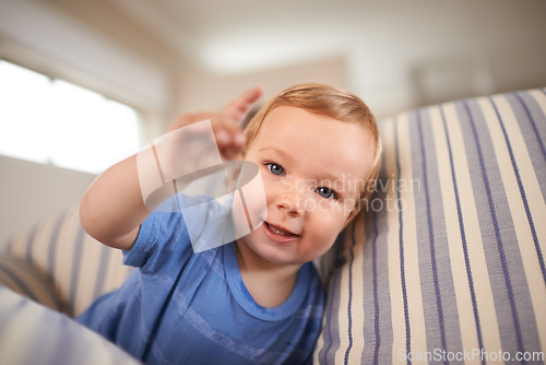 Image of Toddler, playing and portrait of baby on couch in home for fun crawling or learning in living room. Happy, boy or face of a curious male kid on sofa for child development or growth in a house alone