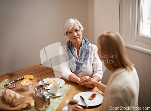 Image of Mother, daughter and home with smile for holding hands in table for bonding, support and visit. Meal, family and tea with food for conversation on break, leisure and happiness for coffee and care.