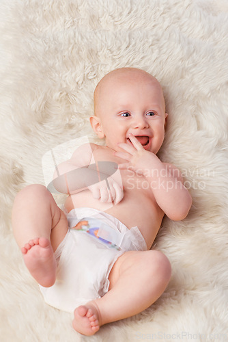 Image of Happy baby, diaper and laugh in bedroom, furry blanket and playtime in cute for child development. Infant, kid and wellness for playing, adorable and positive on rug in house for home and toddler fun