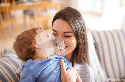 Image of Mother, baby and kiss for love in embrace, care and support or relax in living room and comfortable. Mommy, son and affection for bonding in childhood, security and happiness in hug or smile on face
